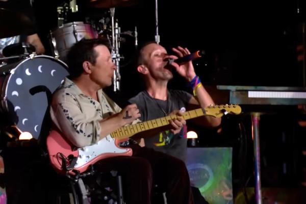 Michael J Fox playing guitar alo<em></em>ngside Coldplay during their encore performance at Glastonbury