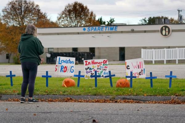 A woman visiting a makeshift memorial outside Sparetime Bowling Alley, the site of a mass shooting in Lewiston, Maine on Oct. 28, 2023